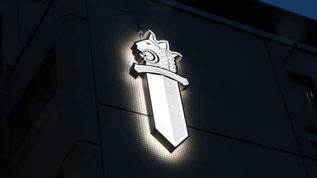 A brightly lit logo on the side of the Helsinki Police Department headquarters building.