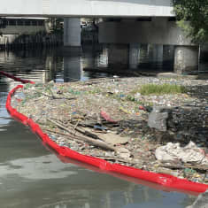 Riverrecycle-yhtiön roskankeräyspuomi sillan ali menevässä joessa Manilassa Filippiineillä