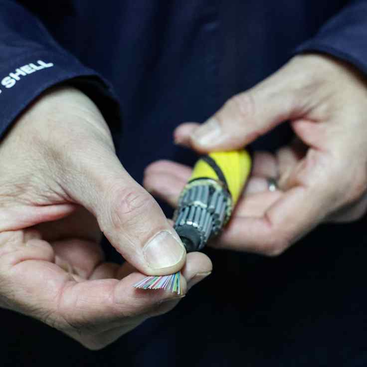 En person håller i en fiberkabel.