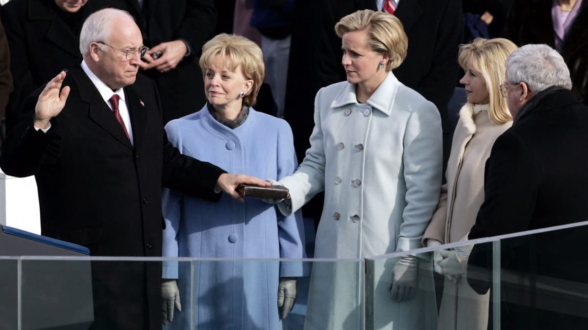Dick Cheney vannoo virkavalaa toinen käsi kohotettuna ja toinen Raamatun päällä. Liz Cheney katsoo isäänsä.