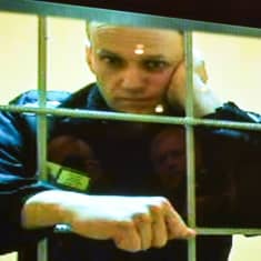 Aleksei Navalnyi videon välityksellä nojaa kaltereihin.