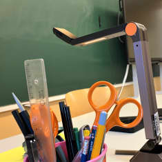Lähikuva luokanopettajan työpöydästä, jolla kyniä, viivottomia ja muita esineitä.