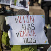 Mielenosoittajia Helsingissä senaatintorilla protestoimassa Venäjän sotatoimia Ukrainassa vastaan. Henkilöllä kyltti, jossa lukee: "Putin alas. Venäjä ulos."