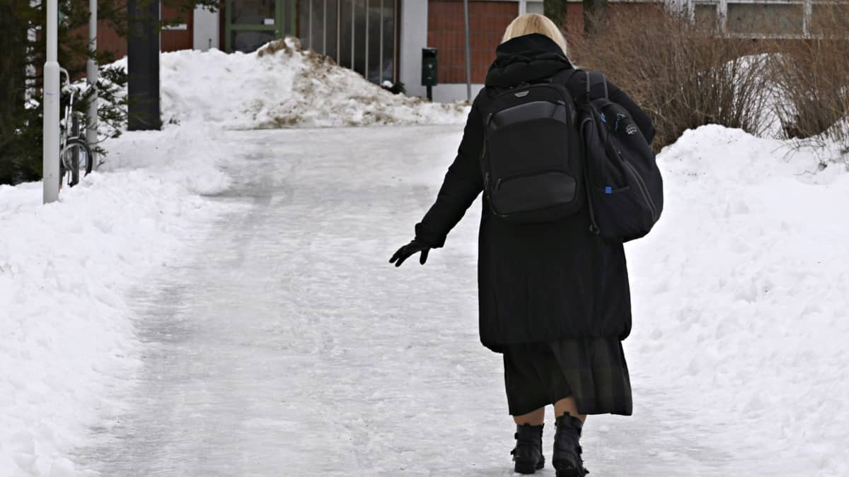 Jalankulkija kävelee varovasti jäisellä jalankulkuväylällä Helsingin Katajanokalla maanantaina 19. joulukuuta 2022.