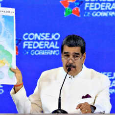 Venezuelan presidentti Nicolas Maduro pitää oikeassa kädessään Venezuelan karttaa.