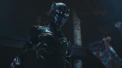 Närbild på den nya Black Panther som står iklädd mask och ser neråt.