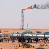 Saudiarabialainen öljykenttä. Poraustornista nousee liekkejä.