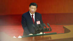 Xi Jinping står vid ett talarpodium och pratar. Han är klädd i kostym och tittar åt sidan.