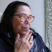 Arja Grek polttaa tupakkaa parvekkeellaan.