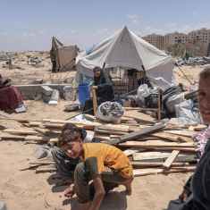 Palestinier som flytt från Rafah i södra Gaza sitter vid sitt tält i Khan Yunis den 12 maj 2024.