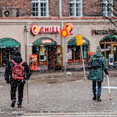 Two people with crutches walking in Hakaniemi, Helsinki.