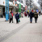 Ihmiset kävelevät Hämeenlinnan reskalla torikojun ohi.
