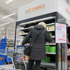 Nainen tutki hyllyä jossa lukee Last Chance