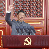 Kiinan presidentti Xi Jinping käsi ylhäällä.