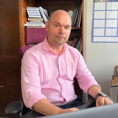 Orimattilan kaupunginjohtaja Kalle Larsson istuu työpöytänsä ääressä ja katsoo kameraan. Lähikuvassa mies, jolla vaaleanpunainen kauluspaita.