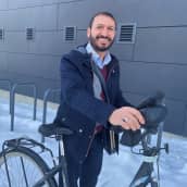 Ali Modareszadeh taluttaa pyöräänsä lumisella parkkipaikalla Oulussa. 