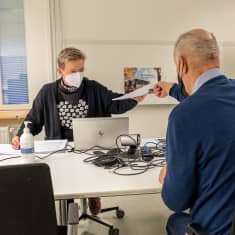 Vaalityöntekijä Veikko Ahola ojentaa Keski-Suomen aluevaalilautakunnan sihteerille Pauliina Mäenpäälle vihreiden ehdokaslistapaperit toimistohuoneessa.