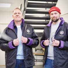 Niklas Törn ja Teemu Artukka musta-violetit TPS-logolla varustetut kansitakit päällä portaikon edessä.