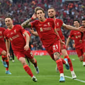 Liverpoolin kreikkalaispuolustaja Kostas Tsimikas juhlii joukkuekavereidensa kanssa FA Cupin voittoa.