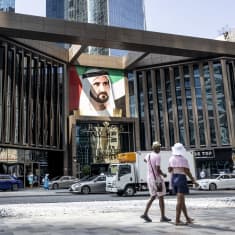 Katunäkymää Dubaissa. Turistit kävelevät Mohammed Binn Al Maktoum kuvan edessä.