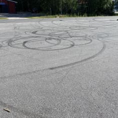 I asfalten ses flera runda och mörka ringar efter att någon har slirat med moped.