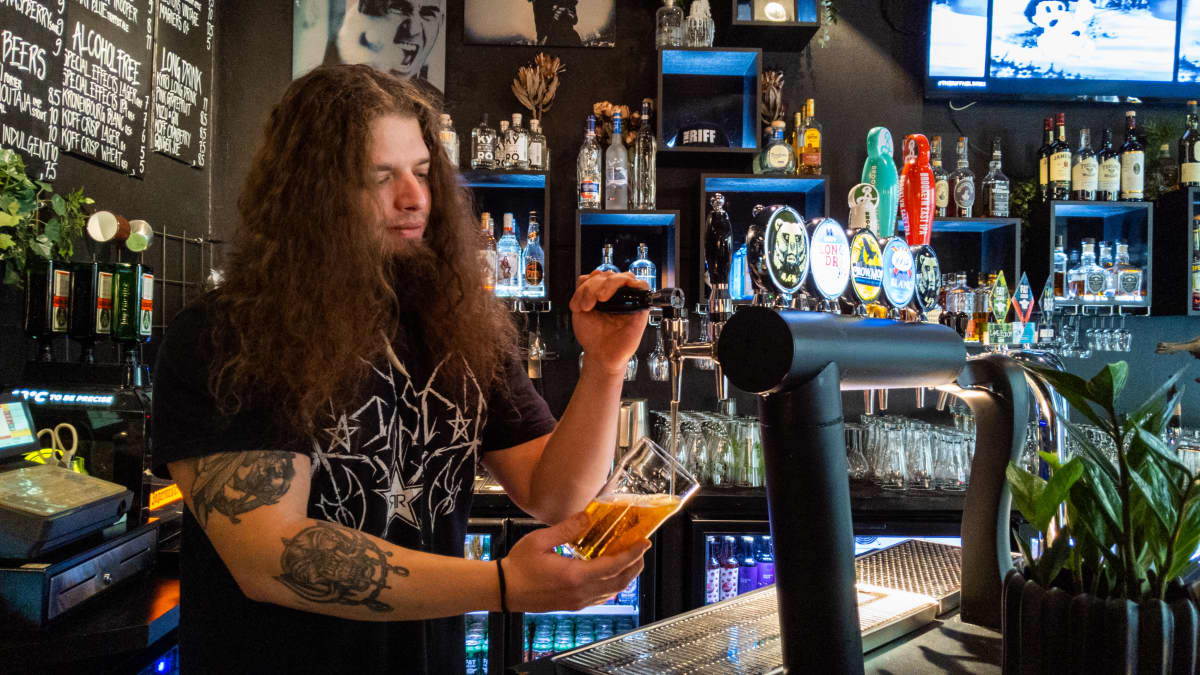 Baarimestari Samuel Honkavaara kaataa olutta lasiin The Riff baarissa.
