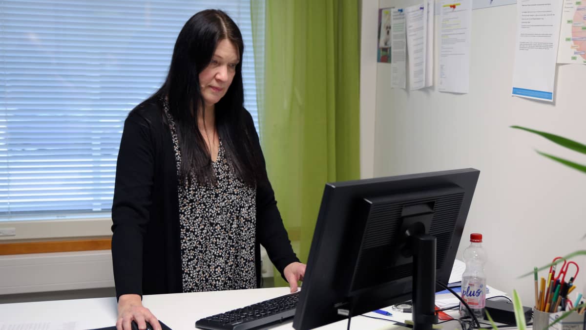 Pihkapuiston toimintakeskuksen johtaja Leena Asikainen tekee töitä tietokoneella.