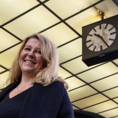 Kaupunkimaantieteen professori Mari Vaattovaara ja hänen takanaan Stockmannin kello.