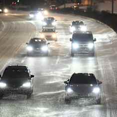 Cars driving in an evening snowstorm.
