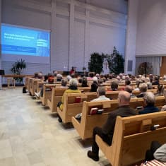 Yleisö istuu kuuntelemassa Henkimaailman kohtaaminen -nimistä luentoa Kallaveden kirkossa Kuopiossa.