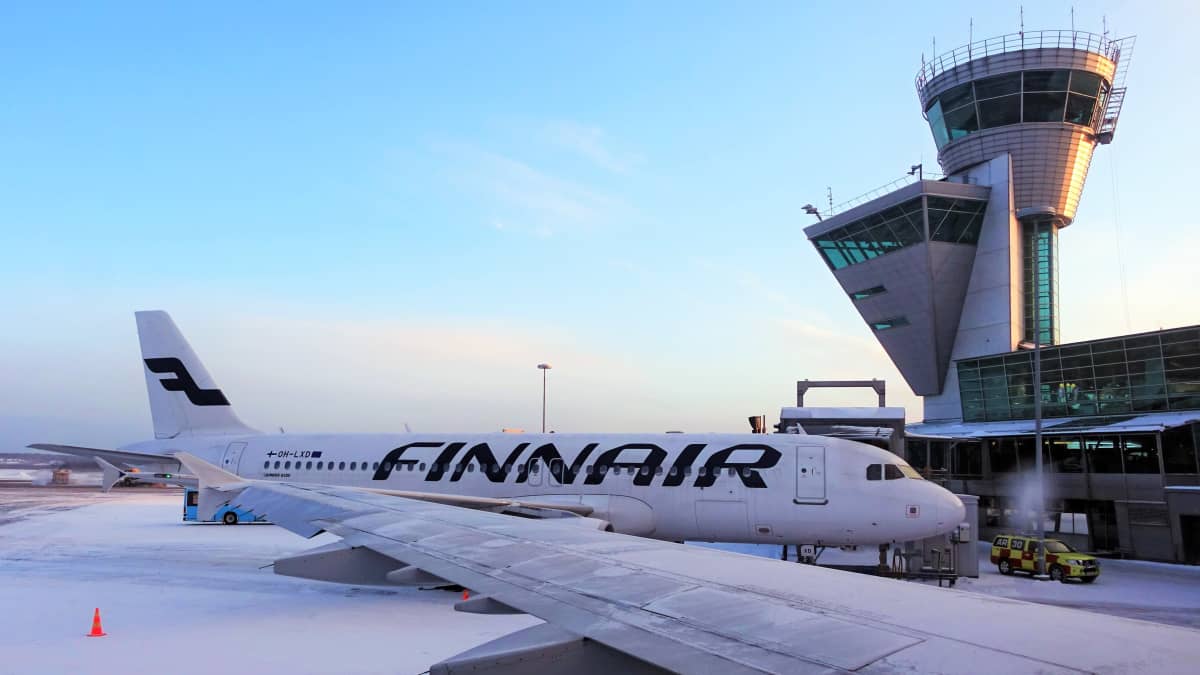 Ett Finnairflyg står på marken vid Helsingfors-Vanda flygplats. Ett annat flygplan syns i förgrunden. Det är snö på marken.