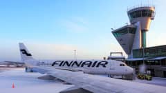 Kuvassa Finnairin lentokone Helsinki-Vantaan lentokentällä lumisessa säässä.