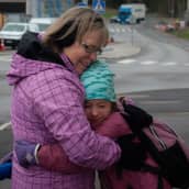 Seija Vahvelainen halaa lapsenlastaan ulkona tämän lähtiessä kouluun.