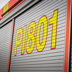 Paloauton kylkiosa, jossa kirkkaankeltaisella kirjoitettu paloauton tunnus PI801.