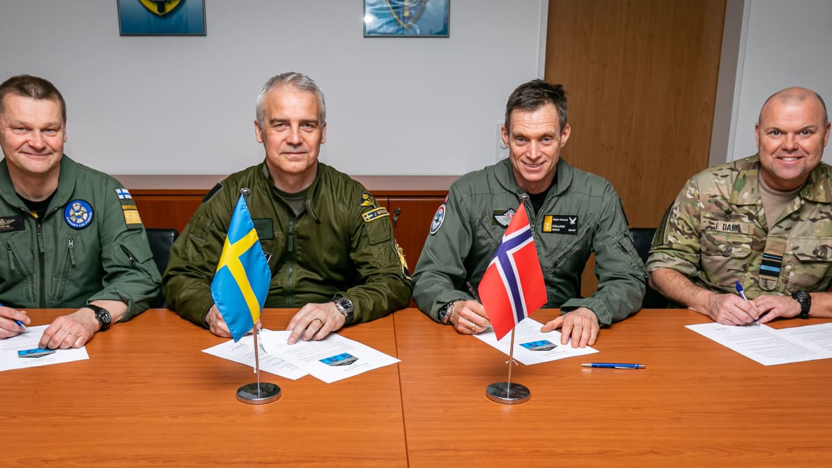 Pohjoismaiden ilmavoimien komentajat istuvat rivissä pöydän ääressä lippujensa edessä.