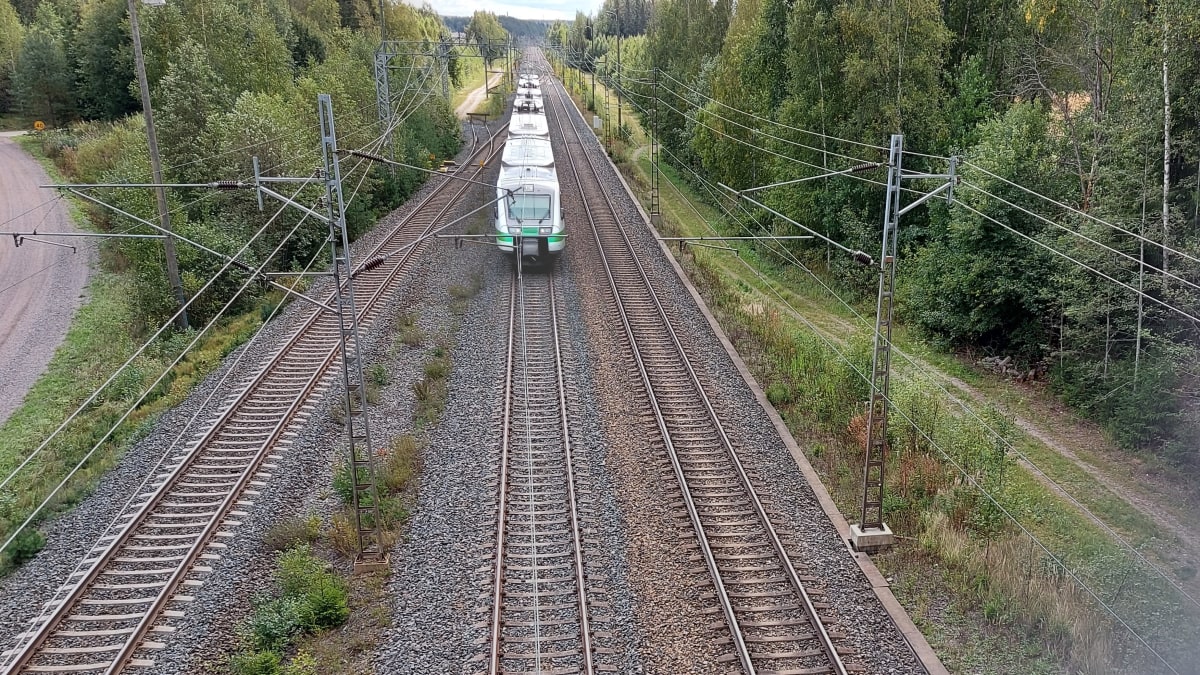 Ylhäältä ylikulkusillalta kuvattu junarata, jossa lähijuna tulee kohti kameraa. 