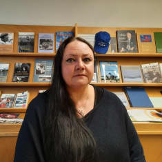 Tanja Karppinen kirjahyllykön edessä