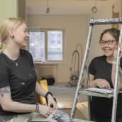Nelli Majamaa ja Sonja Aaltonen nojaavat tikapuihin remontoitavassa kerrostaloasunnossa.