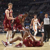 Lauri Markkanen auttaa joukkuekaveriaan ylös lattialta.