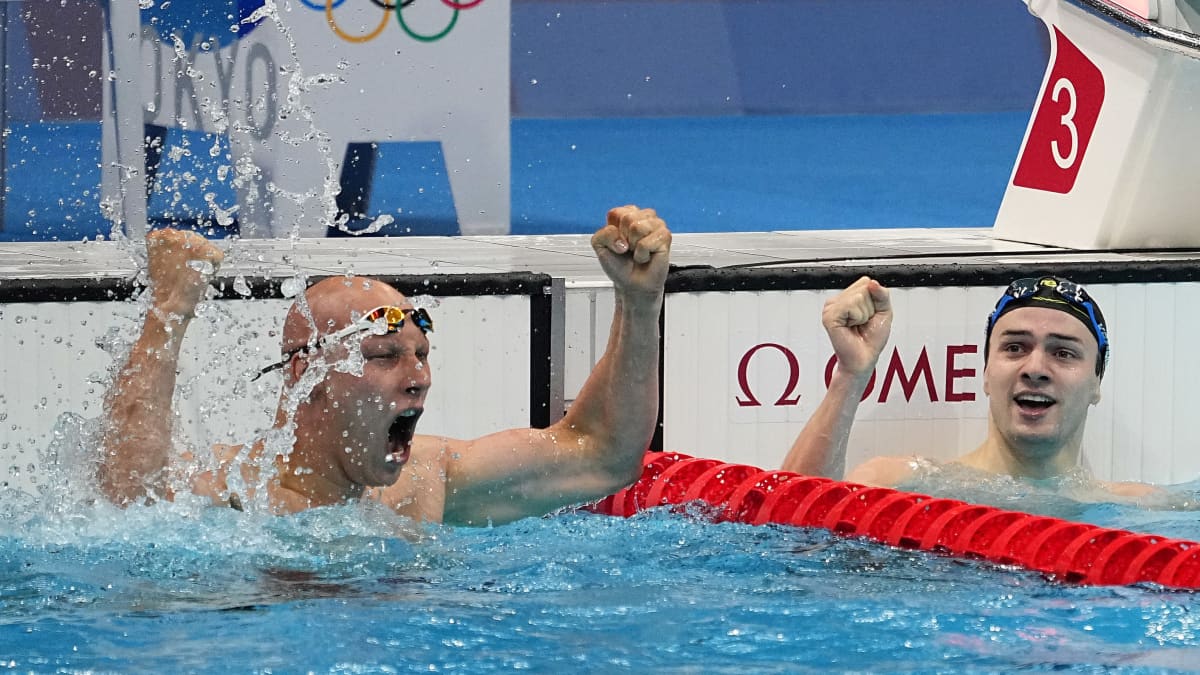 Matti Mattsson jublar och håller upp händerna i vattnet för att fira brons i OS. Bredvid honom hans nederländska motpart som knep silver.