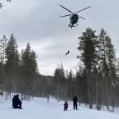Ensihoitaja Juho Kärkkäinen saapuu helikopterilla auttamaan lumivyöryyn joutunutta naista pelastusharjoituksessa