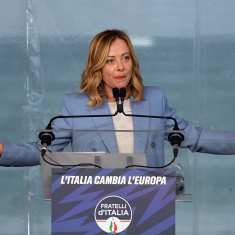Italian pääministeri Giorgia Meloni puhujapöntössä kädet levällään.