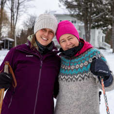 Maija Voutila ja saksalainen Daniela von Linck nojaavat toisiinsa päät yhdessä ja hymyilevät. He ovat ulkona talvivaatteissa ja sauvat käsissään.