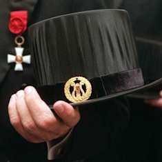 Käsi pitää tohtorinhattua.