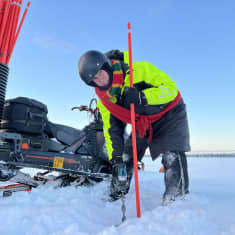 Aimo Leppäkangas poraa jäähän reiän moottorikelkkuran tikotusta varten.