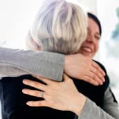 Kaksi naista halaa toisiaan.