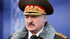 Lukashenka seisoo koppalakki päässään, paksulla turkiskauluksella varustetussa päällystakissa, jossa on kullaväriset olkalaatat.