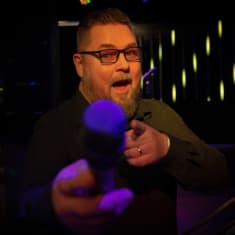 Karaokeisäntä Pete Sinervo mikki kädessään.