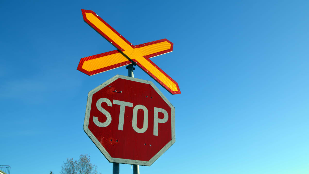 Stop-merkki rautatien tasoristeyksen kohdalla.