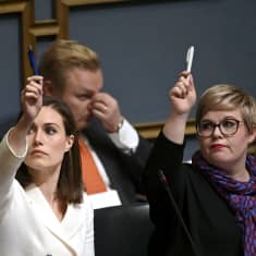Sanna Marin (vas) ja  Annika Saarikko eduskunnassa.